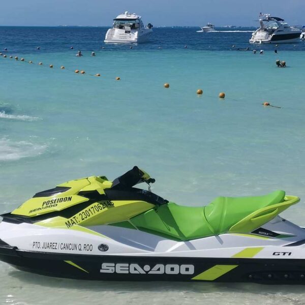 Jet skis y wave runners Sea-Doo GTI verdes listos en las aguas cristalinas de un embarcadero tranquilo en la playa de Canc&uacute;n.